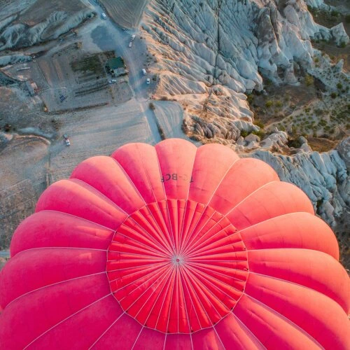 hot air balloon flying over cappadocia valleys in turkey