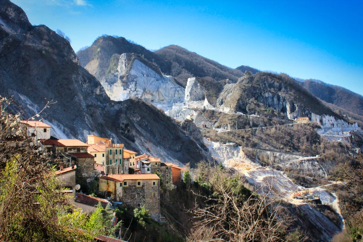 the view from colonnata of the village and marble quarries behind